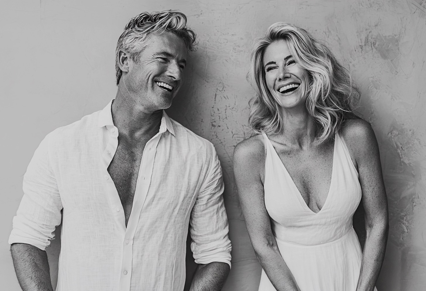 Editorial black-and-white portrait of a couple, laughing